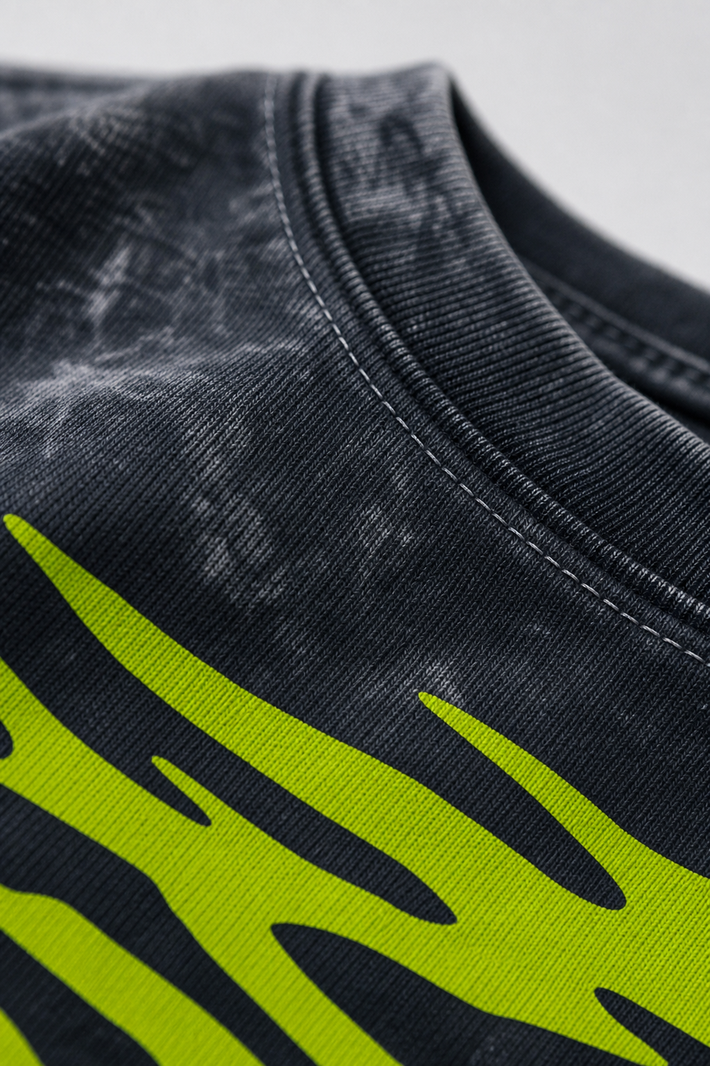 Close-up view of 240 GSM acid wash cotton texture and custom printed graphic detail